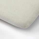Beige cushion with woven texture, soft and plush, zipper detail.
