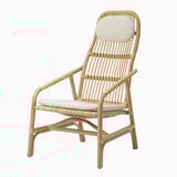 Wicker armchair with cushions. Easy-clean, zippered covers for seat and headrest, offering comfort and support.