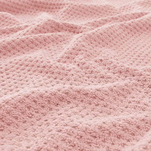 Close-up textured towel, soft, fluffy material. Beige color, intricate weave visible.