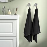 Cozy bathroom with white cabinet, GULVIAL towels, green wall.