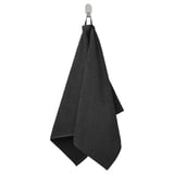 A black GULVIAL towel hangs on a hook. Made of 100% cotton, its soft and fluffy for comfort and absorption.