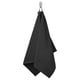 A black GULVIAL towel hangs on a hook. Made of 100% cotton, its soft and fluffy for comfort and absorption.