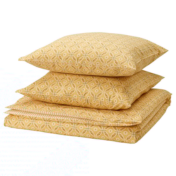 A stack of yellow mustard-colored bedding: 2 pillows and a flat sheet with floral patterns, made of cotton and viscose.