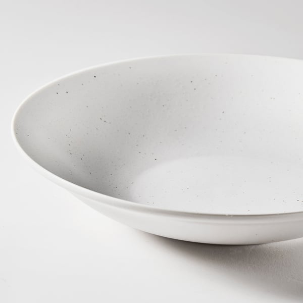 Large, shallow white bowl; sleek, durable design; subtle black speckles.