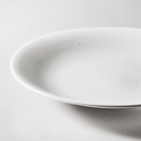 Close-up of HARMYNTA plates smooth, white textured surface, showcasing its high-quality, durable porcelain finish.
