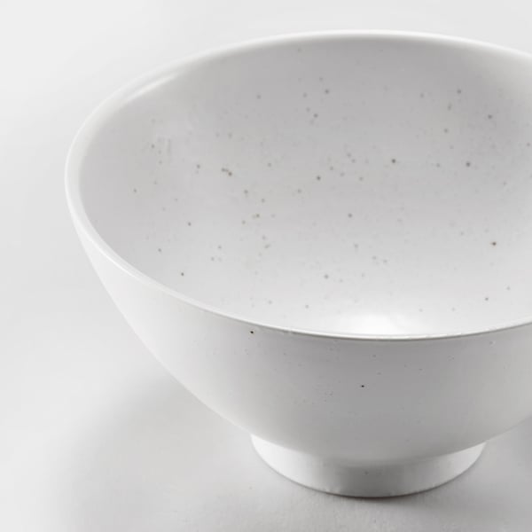 Trendy white porcelain bowl, glistening in soft light, displays modern minimalist design, ideal for meals.