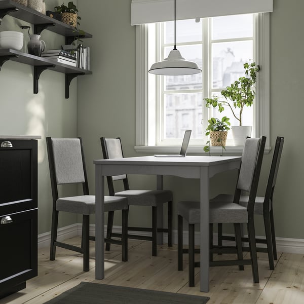 Gray HAUGA wood dining set, small, with 4 padded chairs by window.