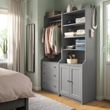 Bedroom with grey HAUGA storage combo: shelves, drawers, & hanging space for clothes. Decorative items included.