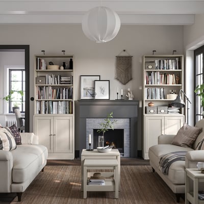 Cozy living room with HAVSTA light gray bookshelves and white sofas, featuring a fireplace, pendant light, and various decorations.