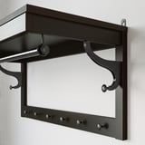 Dark wood coat rack with multiple hooks and a shelf, ideal for hallways.