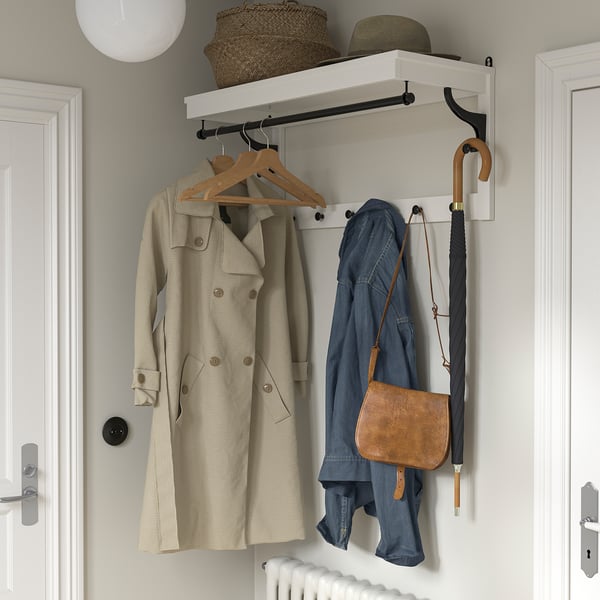HEMNES coat rack in white, holding beige coat, blue jacket, brown bag, umbrella, wicker items, and extra hook. Fits between doors.