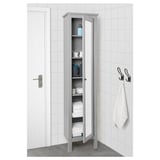 A tall grey cabinet with a mirror door neatly folded towels and bathroom supplies. Four adjustable shelves offer ample storage.