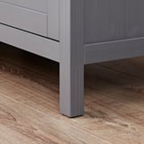 A close-up of a grey wooden cabinet leg, smoothly crafted and finished, showing modern joinery and quality construction.