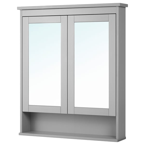 The HEMNES mirror cabinet in gray double doors with tempered glass and a fixed shelf below, ideal for bathroom storage.