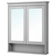 The HEMNES mirror cabinet in gray double doors with tempered glass and a fixed shelf below, ideal for bathroom storage.