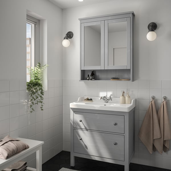 Minimalist bathroom with grey HEMNES vanity, mirror cabinet, and two wall lights.