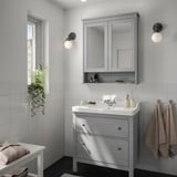 Minimalist bathroom with grey HEMNES vanity, mirror cabinet, and two wall lights.