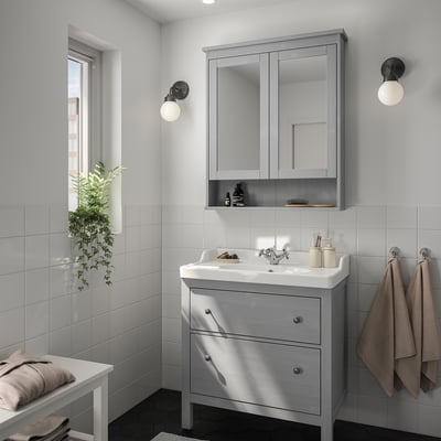 Minimalist bathroom with grey HEMNES vanity, mirror cabinet, and two wall lights.