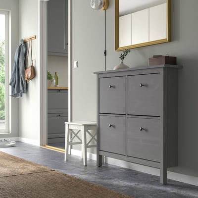 Entrance area with grey HEMNES shoe cabinet, mirror, white stool, coat hooks, and beige rug.