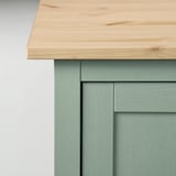 Wooden table top with smooth grain on green cabinet.