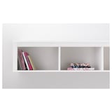 White wall shelf displaying colorful books and decorative boxes. Part of HEMNES series by ikea.
