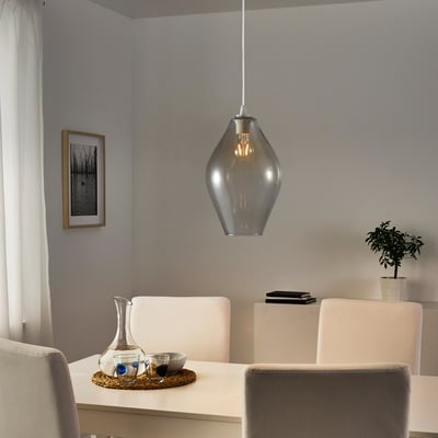 Modern dining setup with warm light, table setting, plant, and wall art.