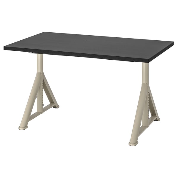 An idaho black desk with beige metal legs, adjustable and angled for stability.