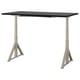 An IDÅSEN desk, rectangular with a black top and beige legs. Its adjustable, sturdy, and has a cable management solution.