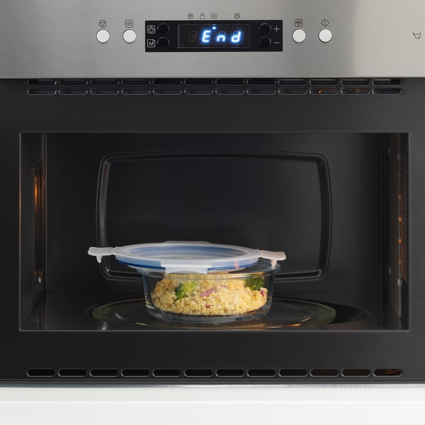 A glass food container with a leak-proof lid inside a microwave, ready to reheat leftovers.