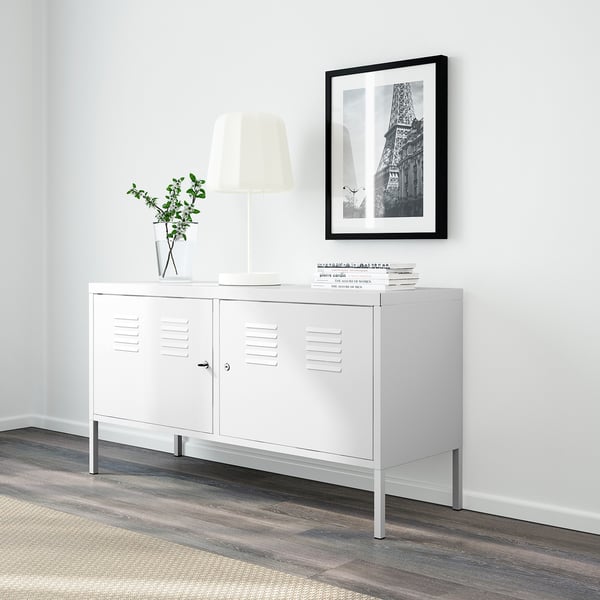 Minimalist white sideboard with lockable doors, lamp, plant, books. Above, eiffel tower photo.