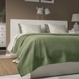 INDIRA bedspread: sage green, cotton, rectangular, layered on double bed. White accents, lamp above.