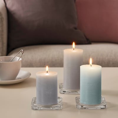 Three blue and white candles in clear holders, creating warm ambiance.