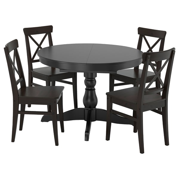 Black round extendable dining table with four matching chairs. Solid wood construction, classic design, high back seats.