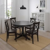 Modern black dining set with round extendable table and four chairs. Added storage unit. Compact yet spacious.