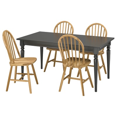 Black extendable dining table with four wooden chairs. Classic design with turned legs and spindle backs.