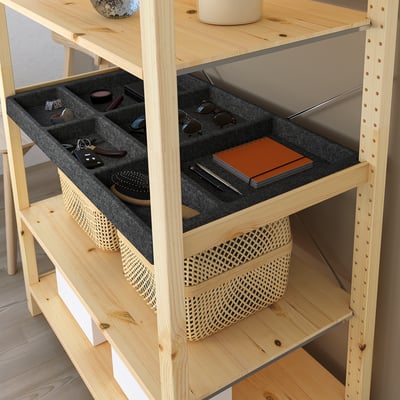 Wooden shelf with felt compartments holding sunglasses, keys, and notebook.