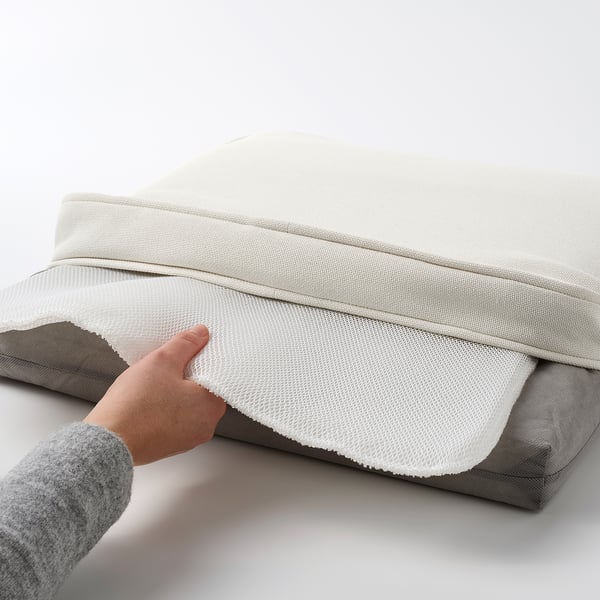 Hand lifting chair cushion. Grey textured cover with white lining, anti-slip dots underneath.