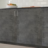Dark grey kitchen cabinets with silver handles and bowl of fruits on top.