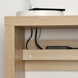 Light wood shelf with visible charging cables and a white charger.