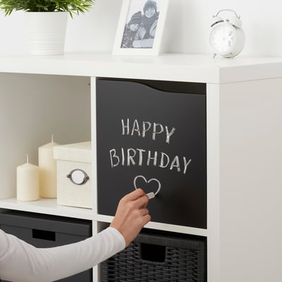 Decorating KALLAX shelf with blackboard, candles, and photo for birthday.