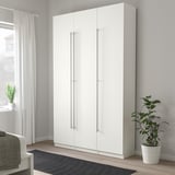 Modern white tall wardrobe with sleek silver handles, taller than plant and bed, minimalist design.