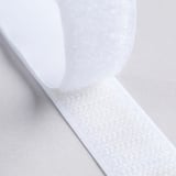 Close-up of white heat-bonding tape, showing texture and thickness. Ideal for no-sew fabric hemming.