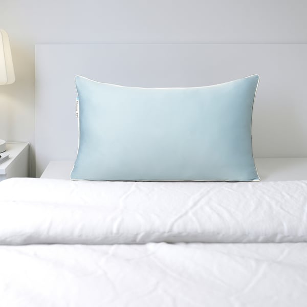 Blue pillow protector on a bed, offering cooling comfort.