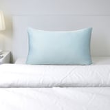 Blue pillow protector on a bed, offering cooling comfort.