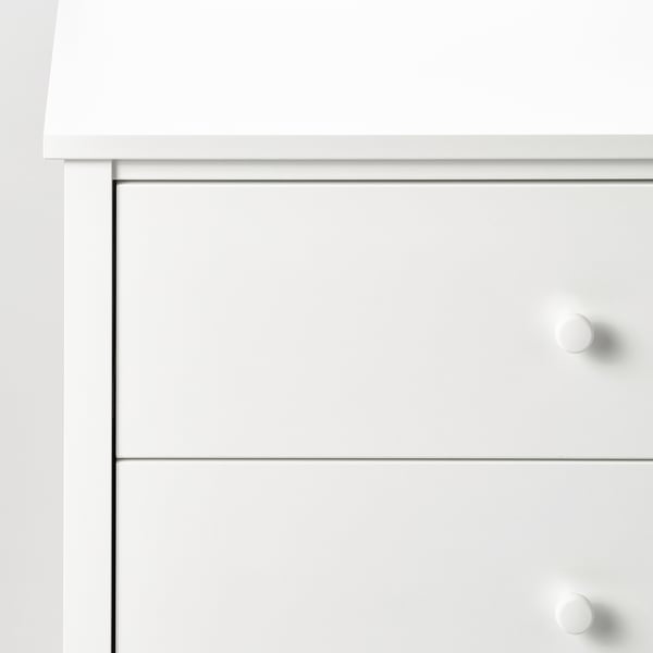 Close-up of white chests side, showcasing smooth finish, clean lines, and knobs.