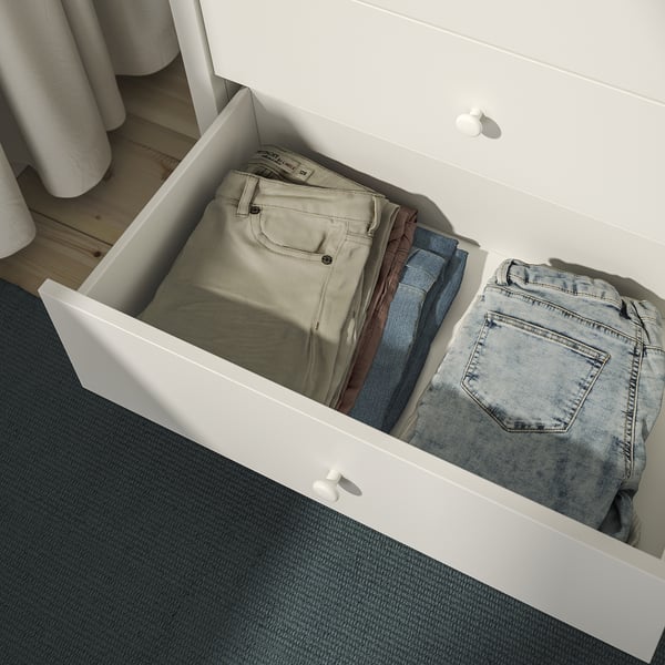Open drawer of KILBERGET chest showing neatly folded pants, demonstrating storage function.