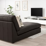Modern living room with KIVIK black leather chaise, pillows, tv, and plant.