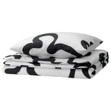 Black and white patterned duvet cover and pillowcases, folded, with abstract shapes.