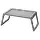 Option: A gray KLIPSK foldable bed tray with v-shaped legs made of polypropylene plastic. It has a flat rectangular top with a groove for holding a tablet.