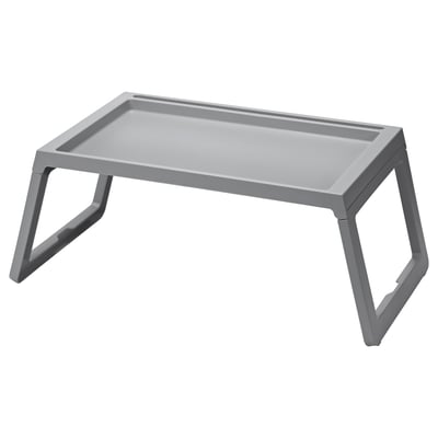 A gray KLIPSK foldable bed tray with v-shaped legs made of polypropylene plastic. It has a flat rectangular top with a groove for holding a tablet.